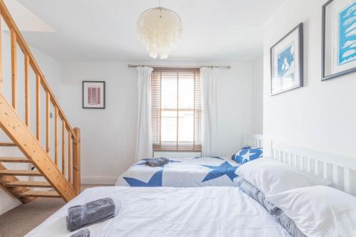 2 Einzelbetten in einem Zimmer mit einer Treppe in der Unterkunft Shell Cottage in Whitstable