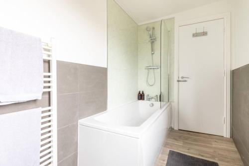 惠斯塔布的住宿－Sandpiper，白色的浴室设有浴缸和淋浴。