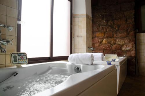 baño con bañera y pared de piedra en Hotel Balneario de Marmolejo, en Marmolejo