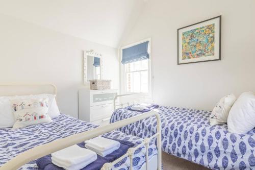 a bedroom with two beds with blue and white sheets at The Old Bakery in Whitstable