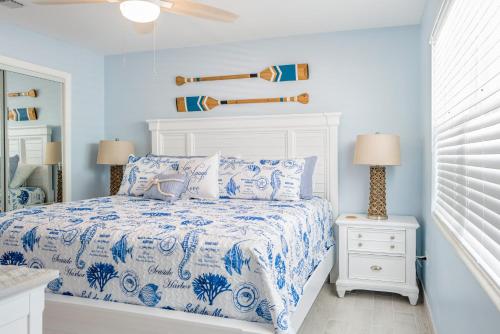 a bedroom with a bed with a blue and white comforter at Waterfront with Boat Lift/Kayaks and Hot Tub in Marathon