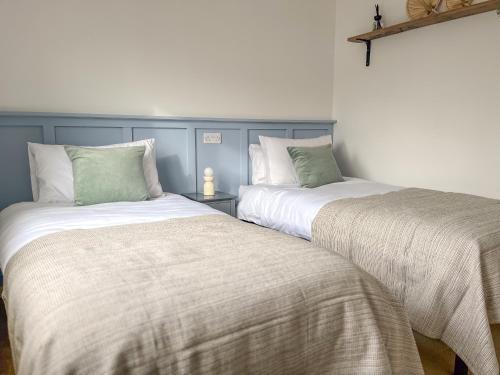 クライストチャーチにあるPeaceful Riverside Lodgeのベッド2台が隣同士に設置された部屋です。
