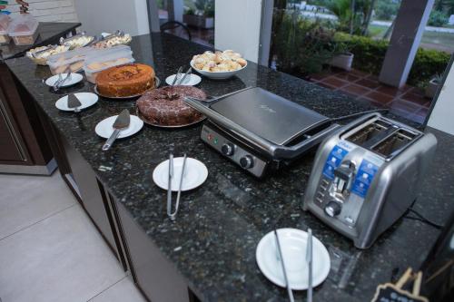 een aanrecht met een broodrooster en wat eten bij Panorama Park Hotel in Igarassú