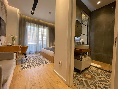 a bedroom with a bed and a sink and a desk at Retreat Apartments in Tirana