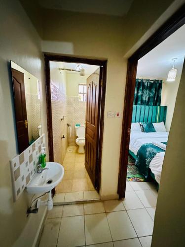 La salle de bains est pourvue d'un lavabo, de toilettes et d'un lit. dans l'établissement Nuna house, à Nairobi