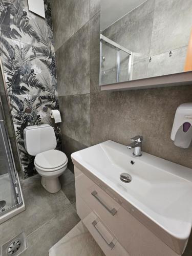 a bathroom with a white sink and a toilet at Hotel Tabor in Sežana