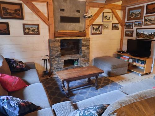 a living room with a couch and a fireplace at Les Granges de la Fontaine in Antignac