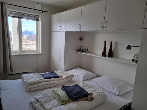 two twin beds in a room with a window at Apartment with fantastic seaview in Henningsvær. in Henningsvær