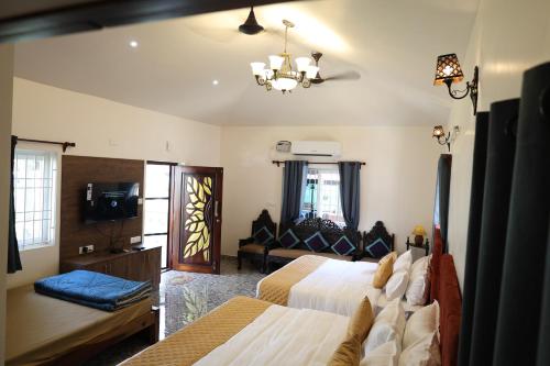 a hotel room with two beds and a couch at Athulya Resort -Leisure and Luxury cottages from EMBEHolidays in Kottaikadu