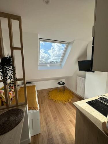 een kleine kamer met een raam en een houten vloer bij Studette entièrement rénovée et lumineuse in Caen