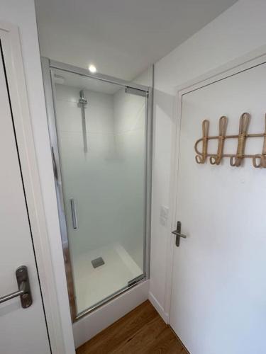 een badkamer met een glazen douche met een kruis aan de muur bij Studette entièrement rénovée et lumineuse in Caen