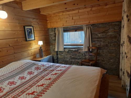 une chambre avec un lit, une chaise et une fenêtre dans l'établissement Les Granges de la Fontaine, à Antignac