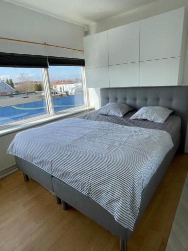 a bed in a bedroom with two large windows at VS-Guesthouse in Copenhagen