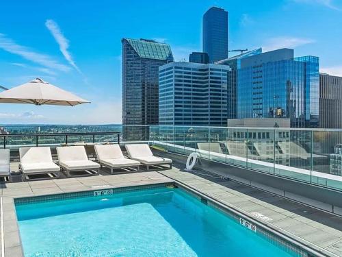 a pool on top of a building with chairs and an umbrella at Luxury 1 Bedroom 1Bath Convention Center in Seattle