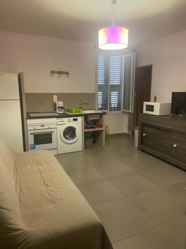 une chambre avec un lit et une cuisine avec un lave-linge dans l'établissement T2 4ème étage Bastia marché, à Bastia