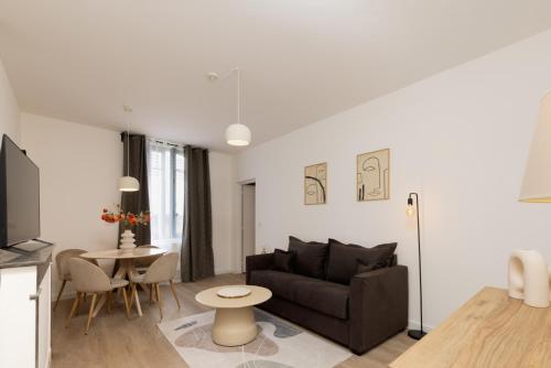 un salon avec un canapé et une table dans l'établissement MarQue Néo Art, à Carcassonne