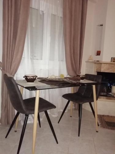 a dining table and chairs in front of a window at House by the sea/Σπίτι στην θάλασσα in Flámbouras