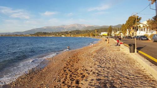 un grupo de personas caminando en una playa junto al agua en House by the sea/Σπίτι στην θάλασσα, en Flámbouras