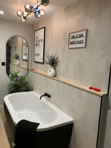 a bathroom with a tub and a mirror and a sink at Abbey Court Guest House in Carlisle