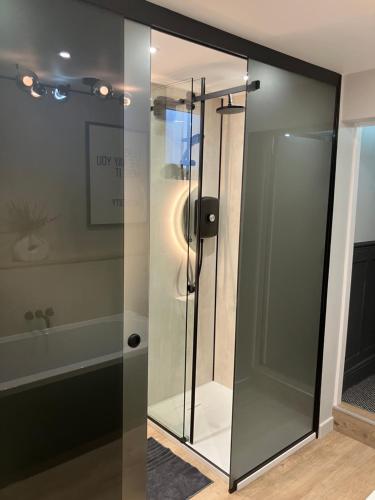a glass shower stall in a bathroom with a tub at Abbey Court Guest House in Carlisle