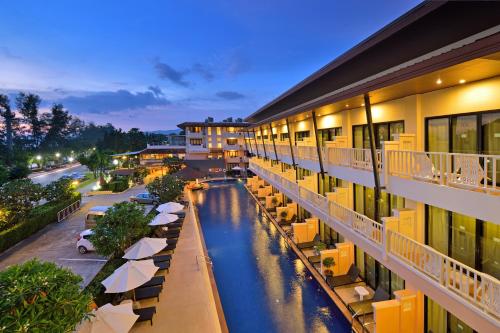 a hotel with a pool and tables and umbrellas at Srisuksant Resort in Ao Nang Beach