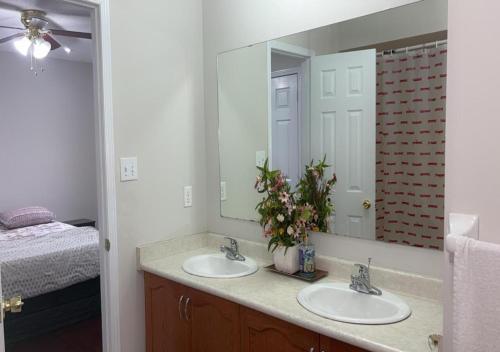 a bathroom with two sinks and a large mirror at Beautiful private Room near Toronto pearson Airport in Brampton