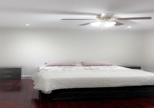 布蘭普頓的住宿－Beautiful private Room near Airport，一间卧室配有一张带吊扇的床