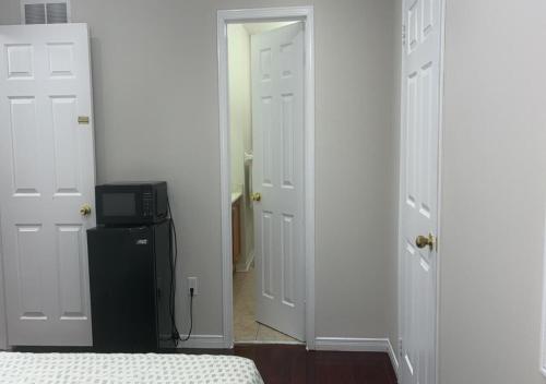 a bedroom with two white doors and a black refrigerator at Beautiful private Room near Toronto pearson Airport in Brampton