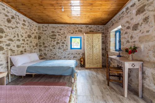 a bedroom with a bed and a desk in a room at La Maison Bleue in Zaros