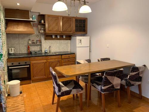 ネア・ミカニオーナにあるRoses Apartmentsのキッチン(テーブル、椅子、冷蔵庫付)