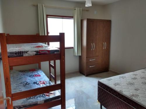 1 Schlafzimmer mit 2 Etagenbetten und einem Fenster in der Unterkunft Casa Temporada Monte H Piuma. in Piúma
