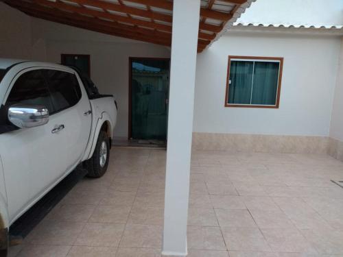 een witte truck geparkeerd voor een huis bij Casa Temporada Monte H Piuma. in Piúma