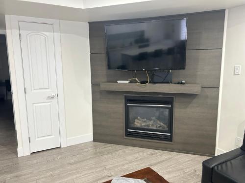 a living room with a fireplace and a flat screen tv at Private Vacation Guest Suite Near Beach in White Rock