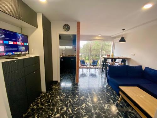 a living room with a blue couch and a tv at Apartament per parelles reformat amb piscina in Calella de Palafrugell