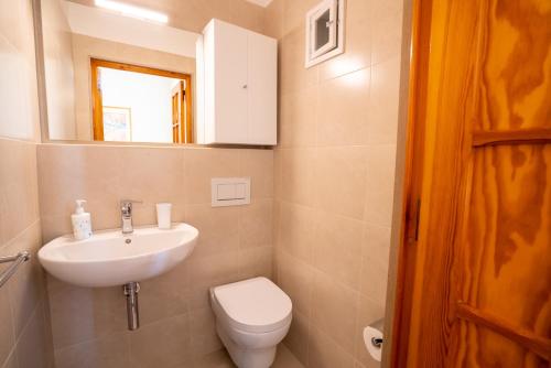 bagno con lavandino, servizi igienici e specchio di Elide Apartments - Comfort a Polignano a Mare