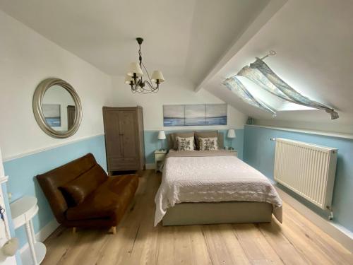 1 dormitorio con cama, silla y espejo en La Besace en Sainte-Croix