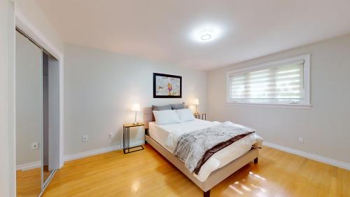 Habitación blanca con cama y ventana en Newly renovated & spacious 4 BDR house in Toronto, en Toronto