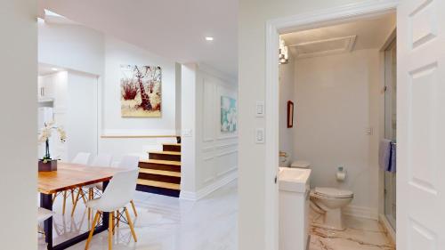 comedor y cocina con paredes blancas, mesa y sillas en Newly renovated & spacious 4 BDR house in Toronto, en Toronto