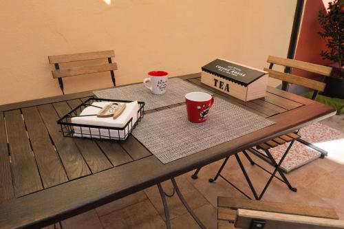 a table with two cups and a book on it at B&B Casa V-Ale in Collegno