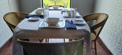 einem Tisch mit Stühlen und einem weißen Tischtuch darauf in der Unterkunft Kitumo Mara Lodges in Mara Simba