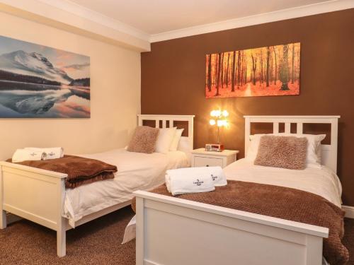 ein Schlafzimmer mit 2 Betten und einem Wandgemälde in der Unterkunft 5 Ladstock Hall in Keswick