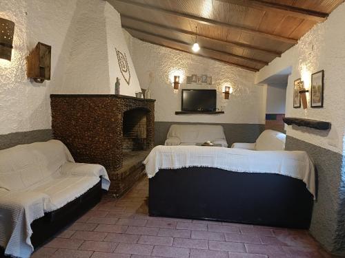 ein Wohnzimmer mit 2 Betten und einem Kamin in der Unterkunft El Mesón de Higuera de la Sierra in Higuera de la Sierra