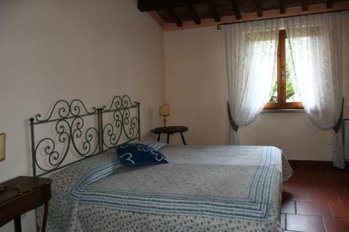 Un dormitorio con una cama con una almohada azul. en Podere Le Monache, en Montaione