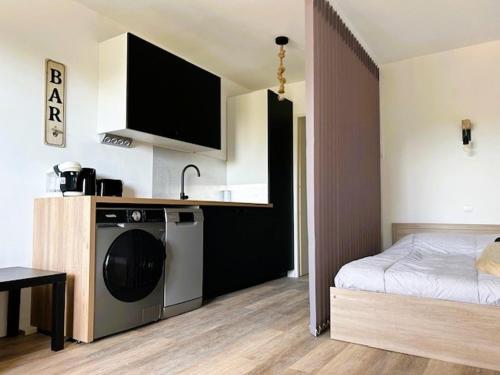- une chambre avec un lit et un lave-linge dans l'établissement HYERES PORT Studio 2 personnes 2 enfants vue HIPPODROME, à Hyères