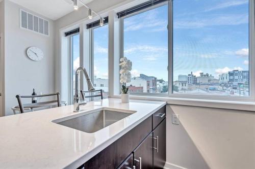 a kitchen with a sink and a large window at City View 1BR w/ Patio by Lively Italian Market in Philadelphia