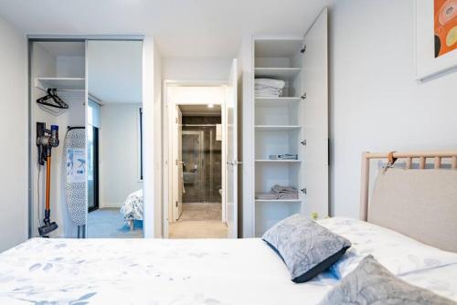 um quarto com uma cama e uma porta para uma casa de banho em Luxury and Stylish Apt on NB Ave em Canberra