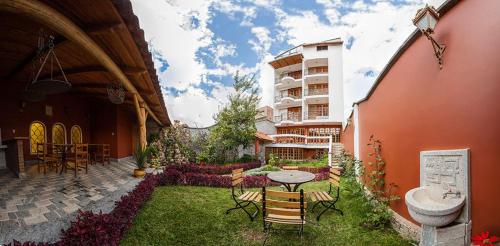 einen Innenhof mit einem Tisch und Stühlen sowie ein Gebäude in der Unterkunft Maimara Hotel in Huaraz