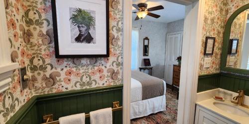 a bedroom with a bed and a bathroom with a sink at The Mason Cottage Downtown in Cape May
