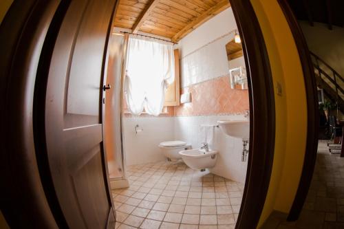 a bathroom with a toilet and a sink and a window at Il Vecchio Mulino in Brecciarola