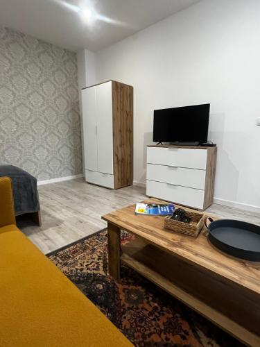 a living room with a tv and a table at Apartamenty DBRW Jeżyce Poznań in Poznań